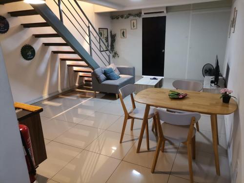 a living room with a staircase and a table and chairs at PINNACLE KELANA JAYA in Petaling Jaya