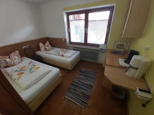 una piccola camera con due letti e una finestra di Appartement Bergblick a Grassau
