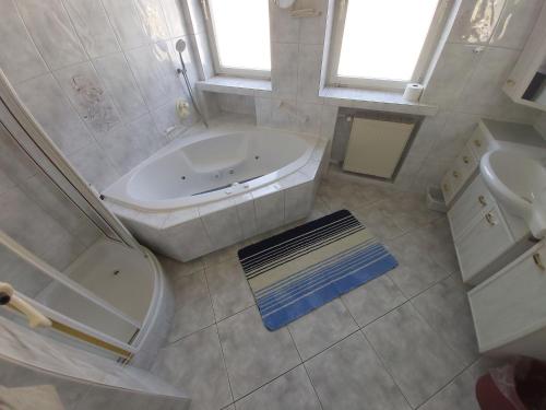 a bathroom with a tub and a toilet and a sink at Appartement Bergblick in Grassau