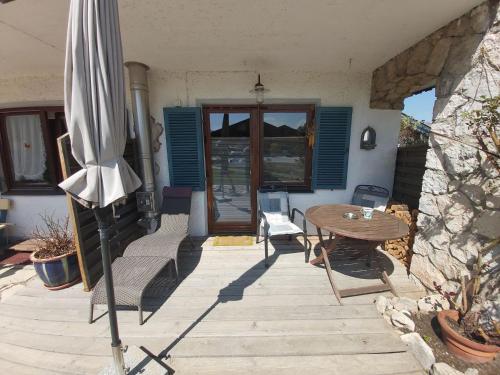 un patio con sombrilla, mesa y sillas en Appartement Bergblick, en Grassau