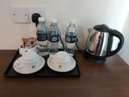 - un plateau avec des assiettes et des bouteilles d'eau sur une table dans l'établissement KB HOTEL, à Kepala Batas