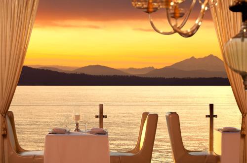 a table and chairs with a view of the ocean at The Edgewater, a Noble House Hotel in Seattle