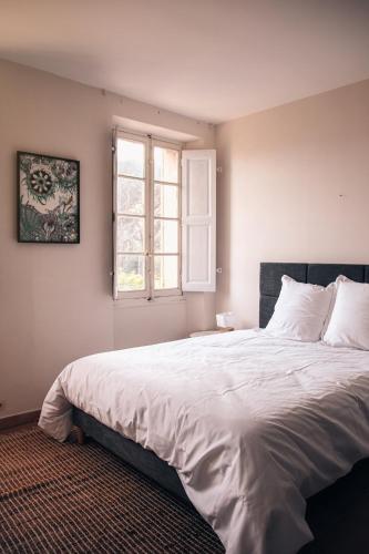 une chambre avec un grand lit blanc avec une fenêtre dans l'établissement Villa Tamaris, à La Seyne-sur-Mer