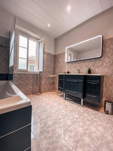 une salle de bain avec un lavabo et un grand miroir dans l'établissement Villa Tamaris, à La Seyne-sur-Mer