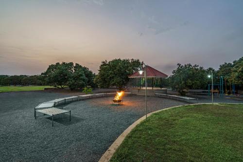 a fire pit in a park with a gazebo at Sterling Gir in Sasan Gir