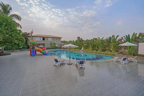 a pool with a slide and chairs and a playground at Sterling Gir in Sasan Gir