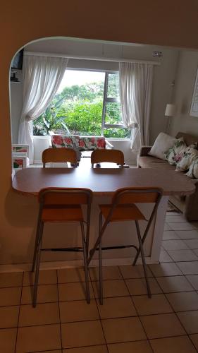 a table and two chairs in a room with a bed at raphia on sea in Mtunzini