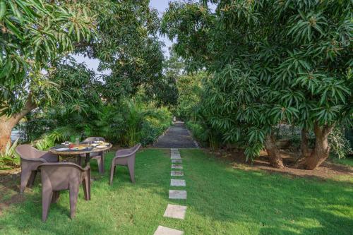 a garden with a table and chairs and a path at Sterling Gir in Sasan Gir