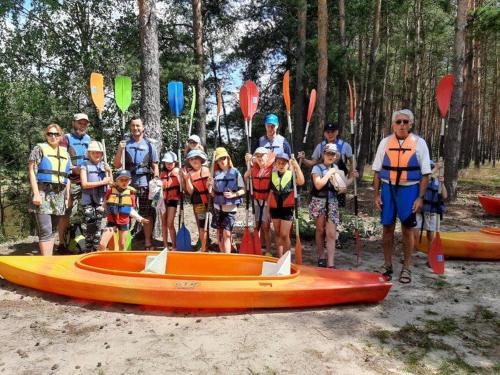 un grupo de personas de pie junto a una canoa en Family Camp Ryczywół - Natura Relaks Spokój, en Ryczywół