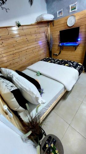 two beds in a room with a tv on the wall at AN edom suite in Eilat