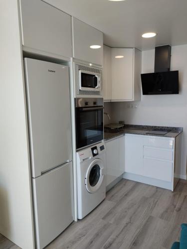 a kitchen with a refrigerator and a washer and dryer at Beach front Esther 6 villajoyosa in Villajoyosa