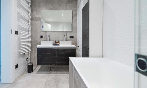 uma casa de banho branca com um lavatório e um espelho em Apartments Traunkai Bad Ischl em Bad Ischl