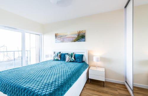 een slaapkamer met een bed en een raam bij Apartos Ustronie Apartments in Ustronie Morskie