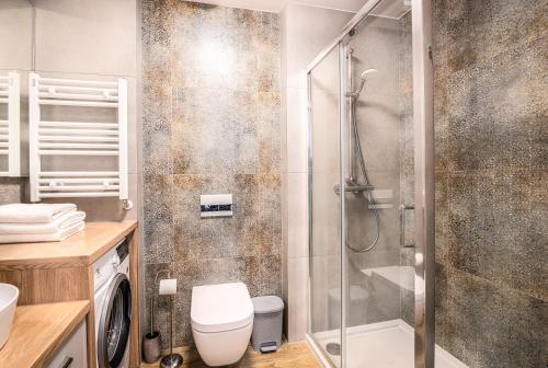 a bathroom with a shower and a toilet at Apartos Ustronie Apartments in Ustronie Morskie