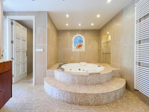 a bathroom with a large tub in a room at Villa Guacarachas in Cacla D'or