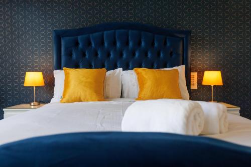 a bedroom with a large bed with yellow pillows at FLATZY - Stylish Abode on Doorstep of Sefton Park *10 minutes to Centre* in Liverpool