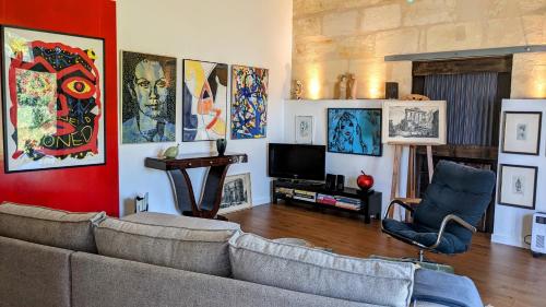 a living room with a couch and a tv at Domaine Mongiron in Nérigean