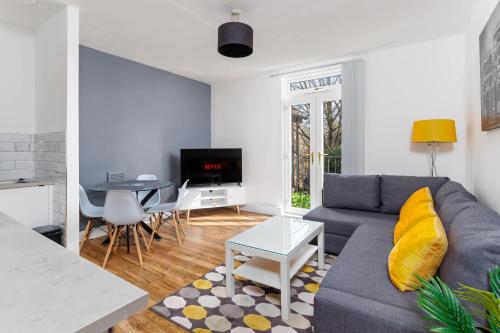 ein Wohnzimmer mit einem Sofa und einem Tisch in der Unterkunft FLATZY - Stylish Abode on Doorstep of Sefton Park *10 minutes to Centre* in Liverpool