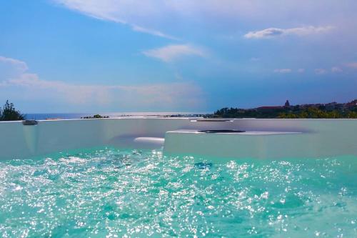 a pool of water with the ocean in the background at Lovely Sunset -Villa Zoe in Nea Moudania