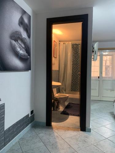 ein Bad mit einer Tür, die zu einem Badezimmer mit einem Bild führt in der Unterkunft Casa Raccuglia in Palermo