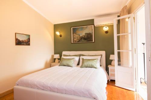 una camera da letto con un grande letto bianco con due cuscini di Grand Skylight a Città di Corfù