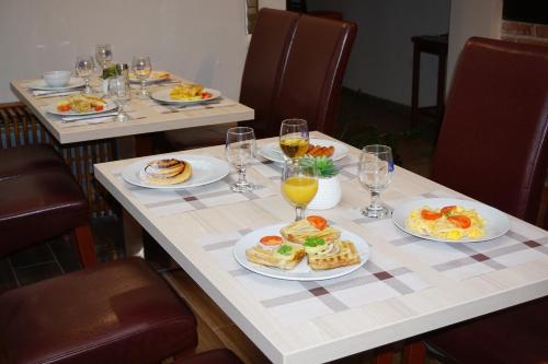 una mesa con platos de comida y vasos de jugo de naranja en Centro Panzió, en Zalaegerszeg