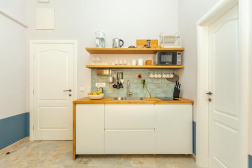 a kitchen with white cabinets and a sink at Kenova apartment Old Town in Dubrovnik