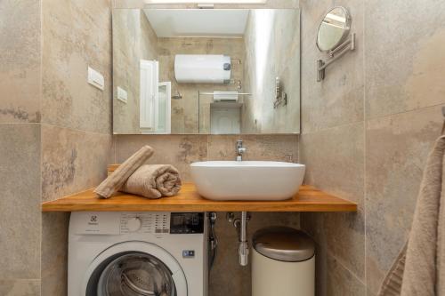 a bathroom with a sink and a washing machine at Kenova apartment Old Town in Dubrovnik