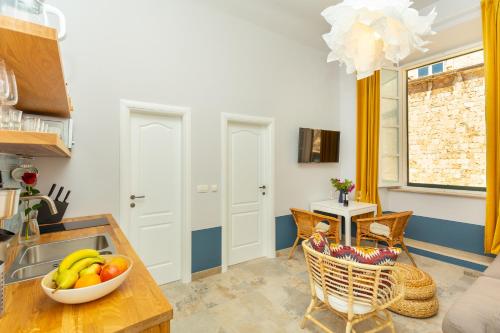 a kitchen with a bowl of fruit on a table at Kenova apartment Old Town in Dubrovnik