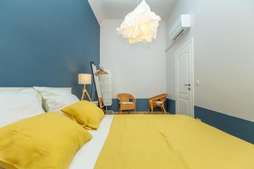 a bedroom with a bed with a yellow blanket on it at Kenova apartment Old Town in Dubrovnik