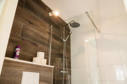 La salle de bains est pourvue d'une douche avec une porte en verre. dans l'établissement Blommehûs, à Workum