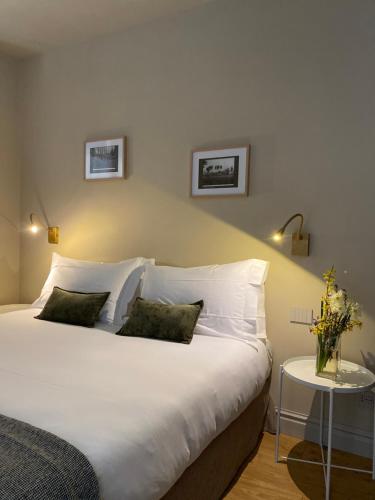 a bedroom with a large white bed with two pillows at Tenuta Pizzone Wine Resort in Rivanazzano