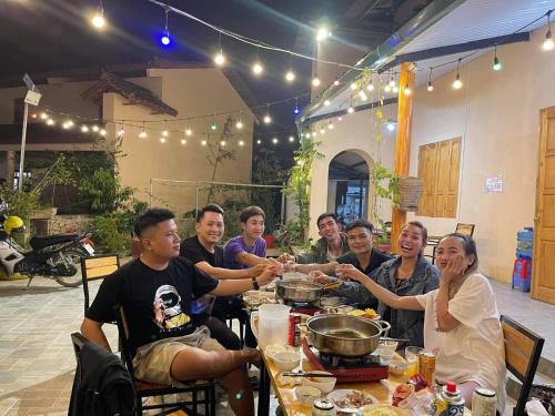 a group of people sitting at a table with food at Meo Vac Valley in Mèo Vạc