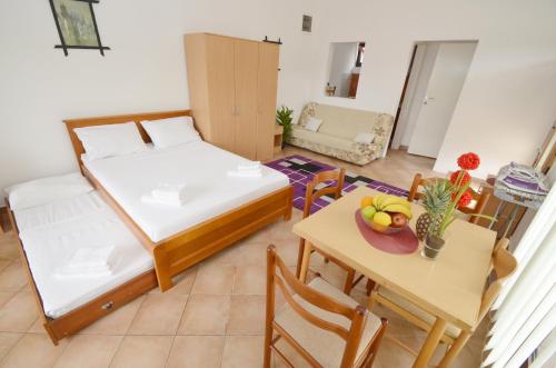 a room with two beds and a table with a bowl of fruit at Apartments Blue Lagoon in Kotor