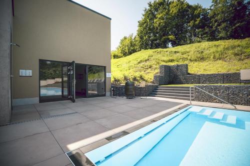 a swimming pool in front of a house at Hotel Halfenstube & Villa Spa 1894 in Senheim