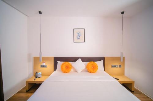 sypialnia z dużym łóżkiem z pomarańczowymi poduszkami w obiekcie SV Chrome w mieście Abudża