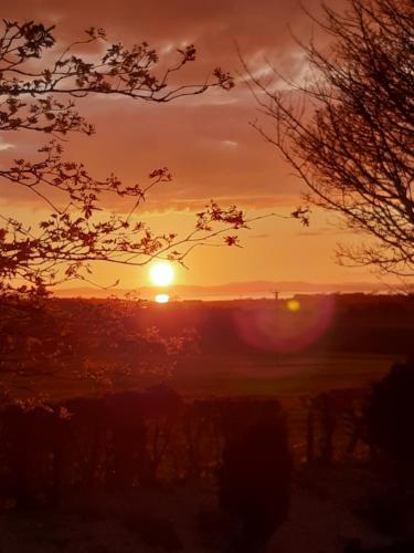 a sunset with the sun setting in the background at 24 The Beeches Caravan Park in Gilcrux