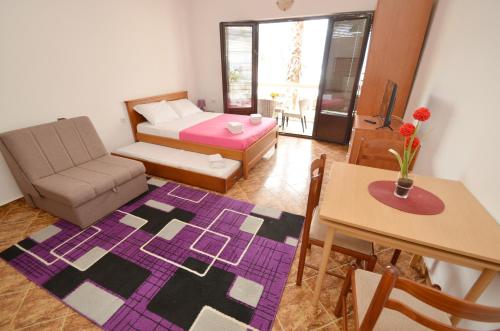 a living room with a couch and a bed and a table at Apartments Blue Lagoon in Kotor