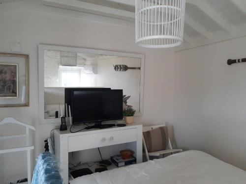 a bedroom with a tv on a white cabinet at Quinta da Atafona in Ribeirinha