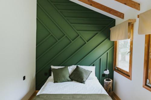 a bedroom with a green wall and a bed at Weź tu Przystań - Mikołajek 1 in Pomiechówek