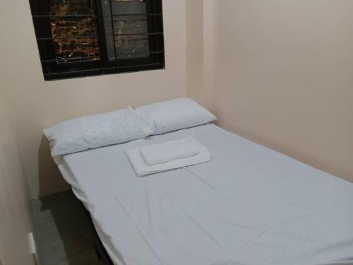 a white bed in a room with a window at RedDoorz @ JJ & KAYE APARTMENT in Carmen