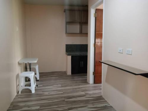 a kitchen with a counter and two stools in a room at RedDoorz @ JJ & KAYE APARTMENT in Carmen