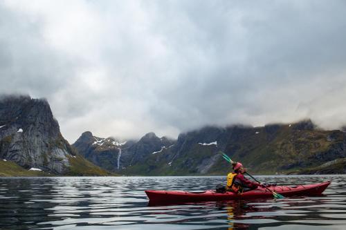 a person in a kayak on a body of water at Sakrisøy Rorbuer in Reine