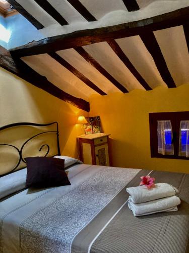 a bedroom with a bed with towels on it at La Alpargateria in Villafranca-Montes de Oca