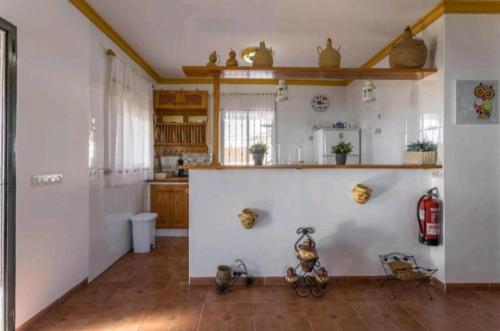 uma cozinha com paredes brancas e pisos em madeira em Casa Laura em Frigiliana