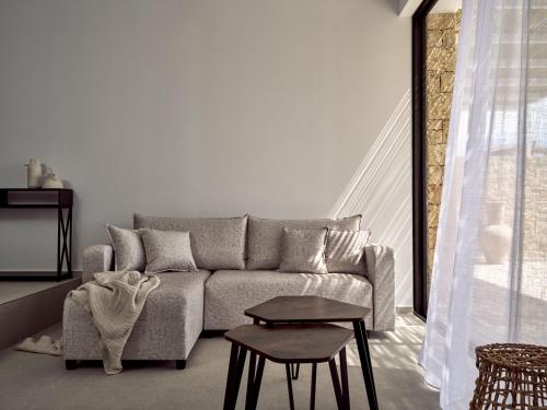 a living room with a couch and a table at The Sall Suites Complex A - Iconic Sea Views, by ZanteWize in Agios Nikolaos