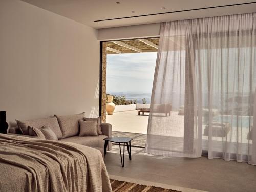 a bedroom with a couch and a large window at The Sall Suites - Complex A in Agios Nikolaos