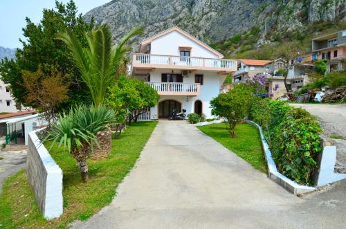 a house with a mountain in the background at Apartments Blue Lagoon in Kotor