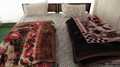 - un lit avec une couette et des oreillers dans l'établissement Garjha Hill Sight Trekking & Camping, à Sir Bhum Chun