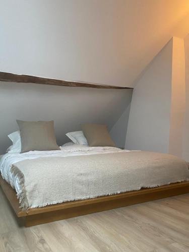 a bed with two pillows on it in a room at Au temps suspendu in Marche-en-Famenne